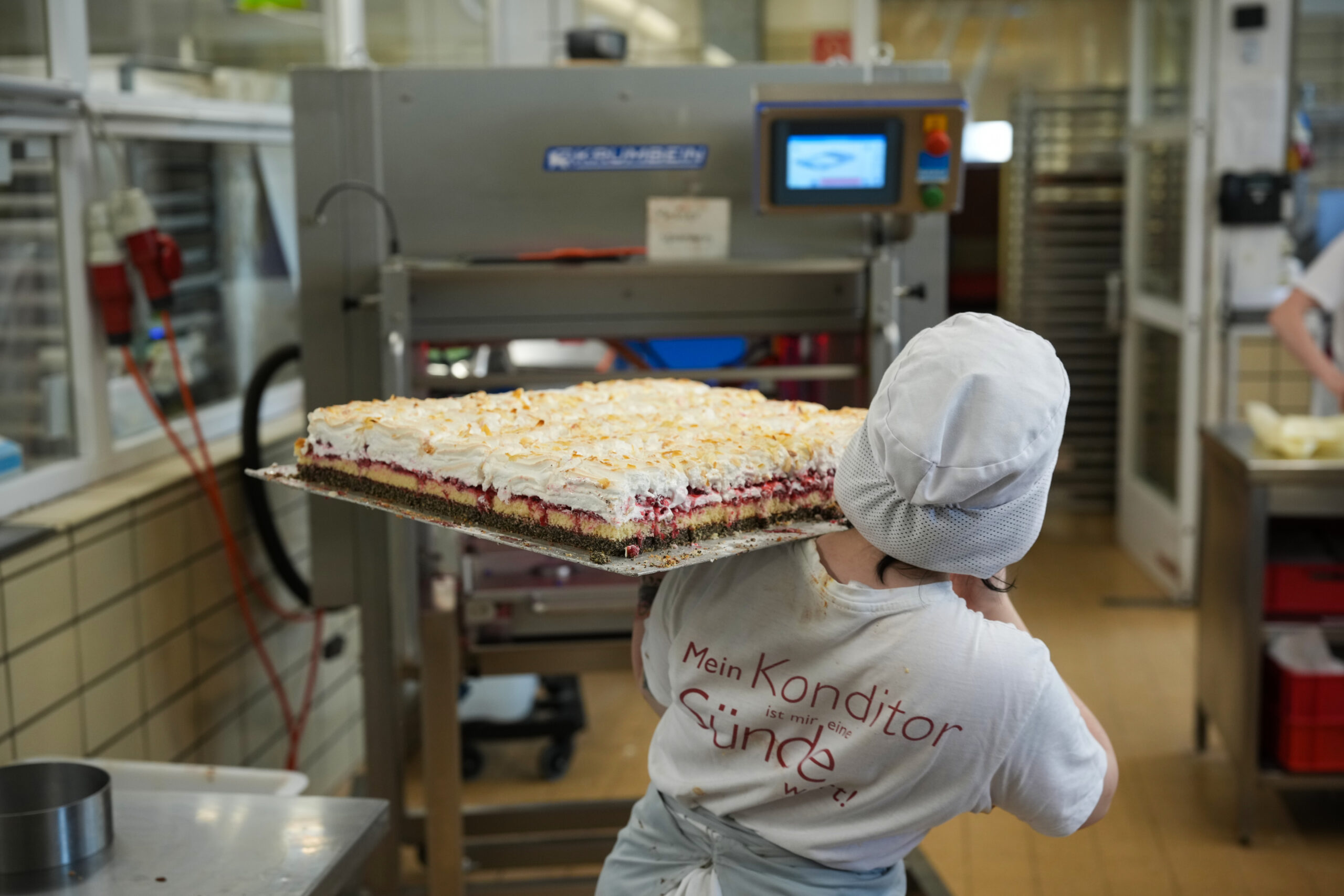 Ofenfrische Blechkreation mit luftigem Baiser-Topping – handgemacht, wie alle Mehlspeisen im Traditionsbetrieb. Auf dem Rücken: das Bekenntnis zur süßen Verführung. © Henry Gasselich