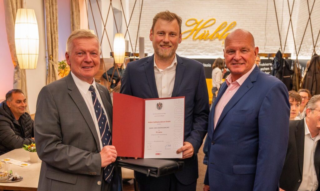 Landesinnungsmeister Josef Angelmayer (links) und Innungsgeschäftsführer Dr. Klaus Puza (rechts) überreichen Alexander Hübler die Ehrenurkunde (Bild: andsocial)
