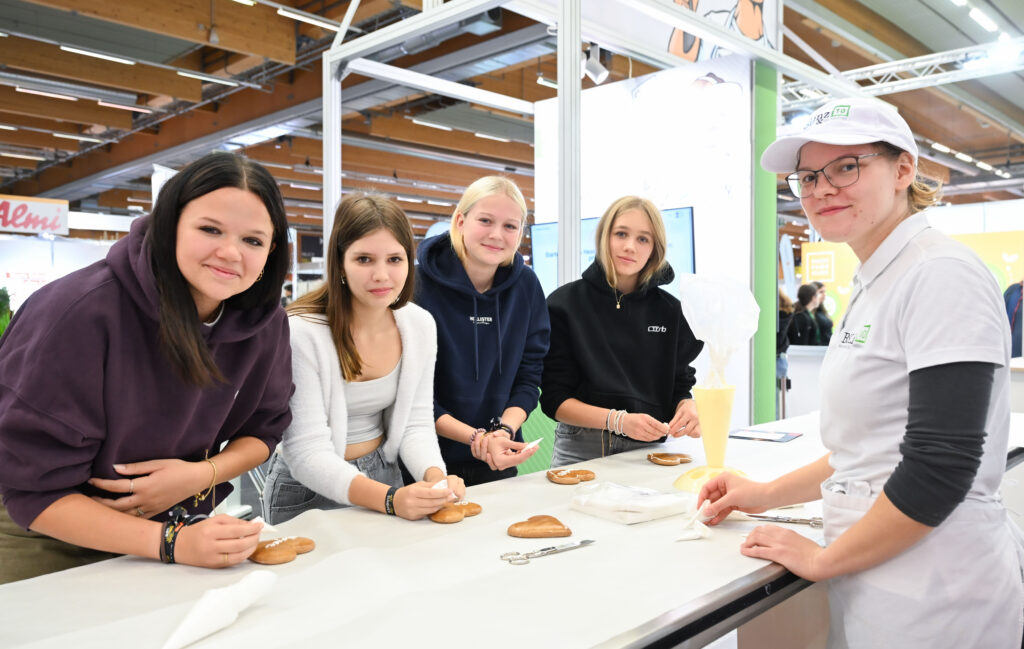 Kreativ und konzentriert: Schüler:innen verzieren Lebkuchenherzen am Stand der Konditor:innen – ein Highlight der Messe „Jugend & Beruf“. © Andreas Röbl/WKOÖ