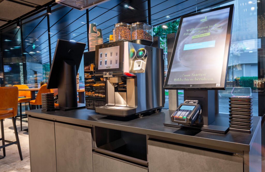 Gegenüber der Bedientheke steht die SB-Station mit Self-Order-Terminal und SB-Kaffeeautomat.© Kim Nguyen