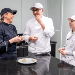 V.l.n.r.: Eva-Maria Kaiser (gewerbliche Geschäftsführerin Billa Plus Marktkonditorei), Konditor Endre Nagy und Lehrling Alexandra Blaha genießen die neue handgemachte Schokoladensorte "Matcha Strawberry". © Billa AG / Robert Harson