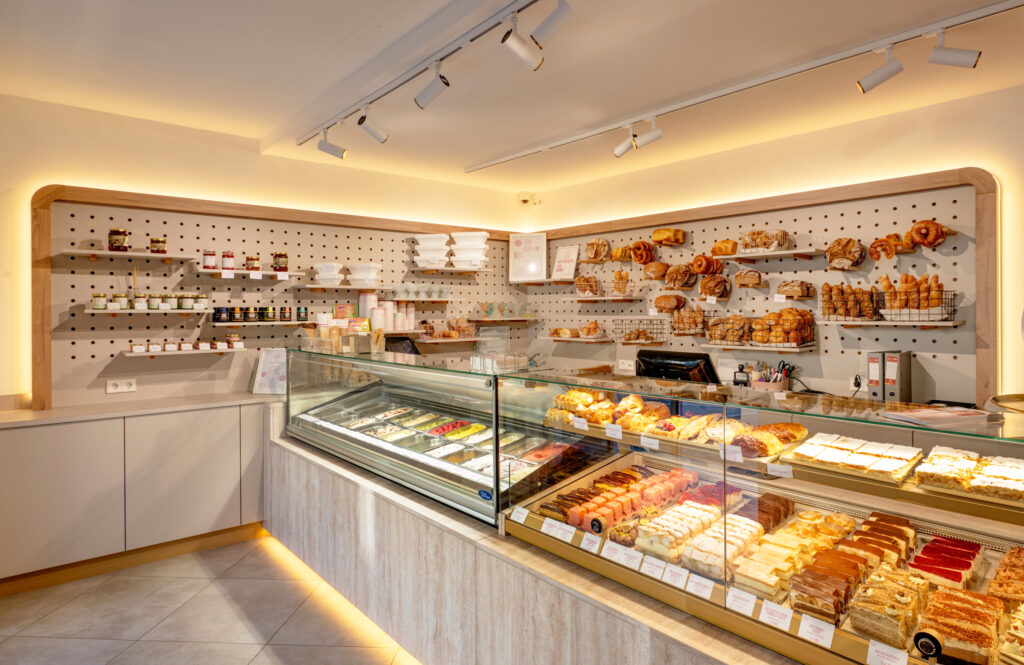 Lichtfriese setzen Theke und Rückwand in Szene – und geben den Mehlspeisen und Broten ihren klaren Auftritt. © Aichinger