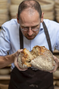 Gerhard Winkler konzentriert sich auf das, was sein Handwerk ausmacht: die Krume eines frisch gebrochenen Brotes – geprüft mit Blick, Erfahrung und Gefühl. © Kapelari Studio