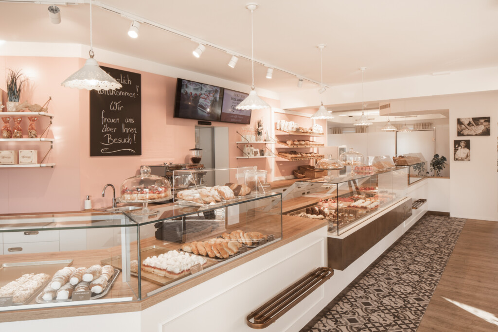 Edel gestaltete Theke in Braun-Weiß in der Konditorei Punschkrapferl in St. Pölten. Konzept und Umsetzung: Vrana Shopdesign. © Zimmerhackl